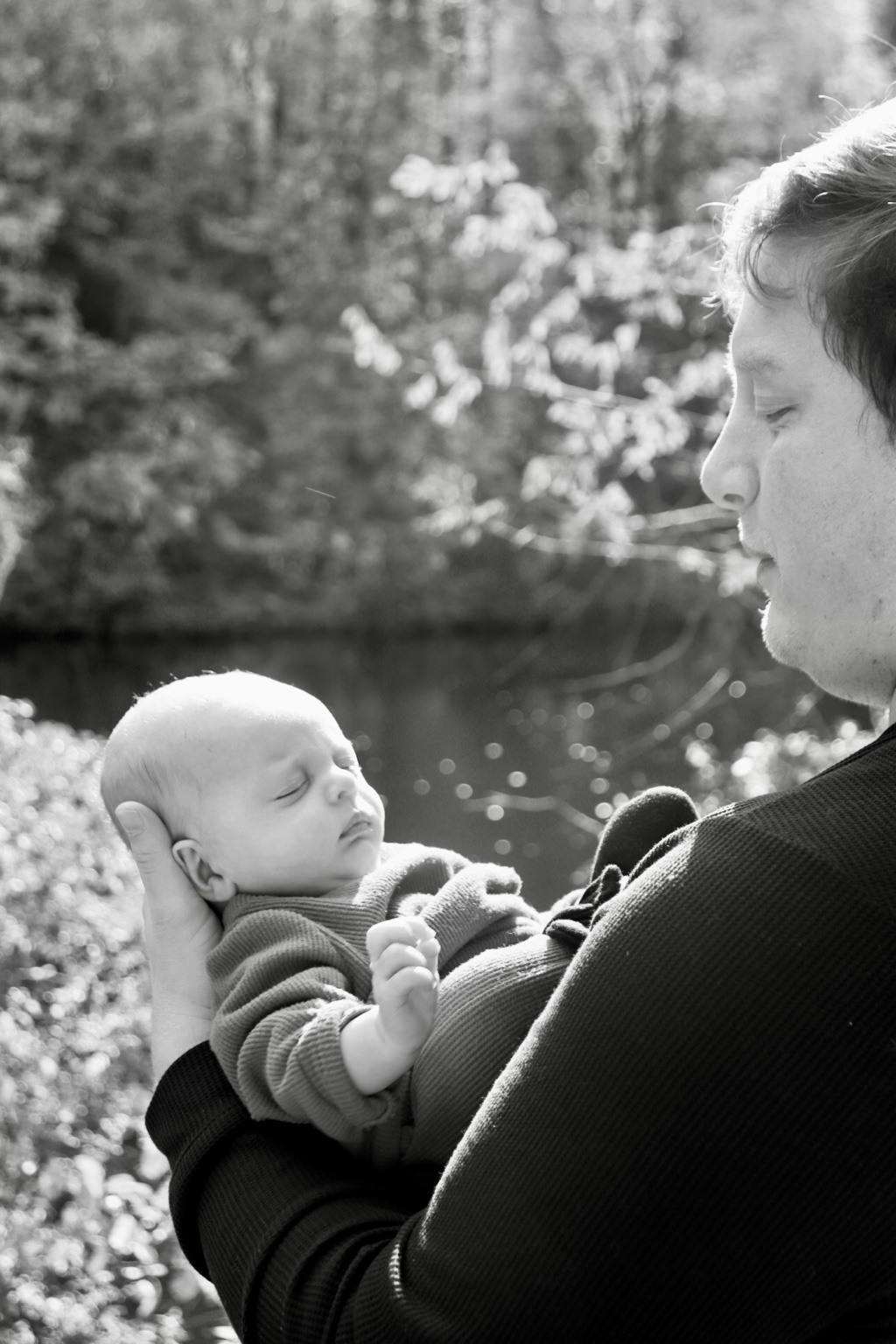 Black and white family portrait of a parent holding a baby